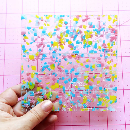5 inch square acrylic ruler by Feral Notions in Confetti colorway, for cutting batting, tracing matboard, and measuring fabric in needlepoint finishing projects
